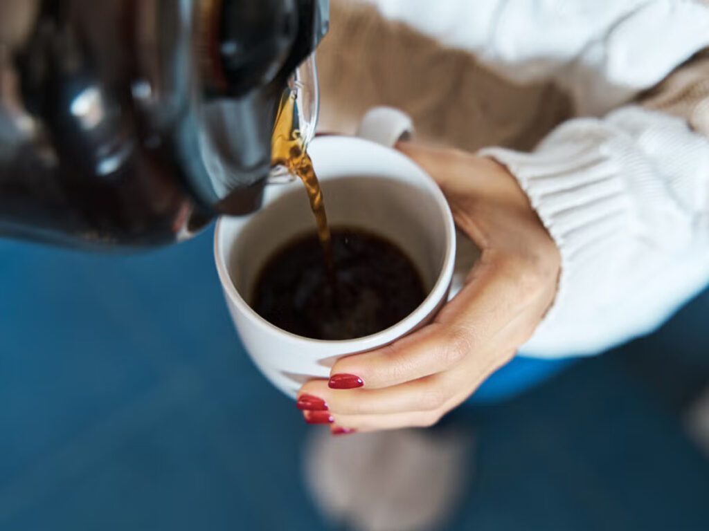 woman pouring herself hot coffee to a mug royalty free image 1705614312